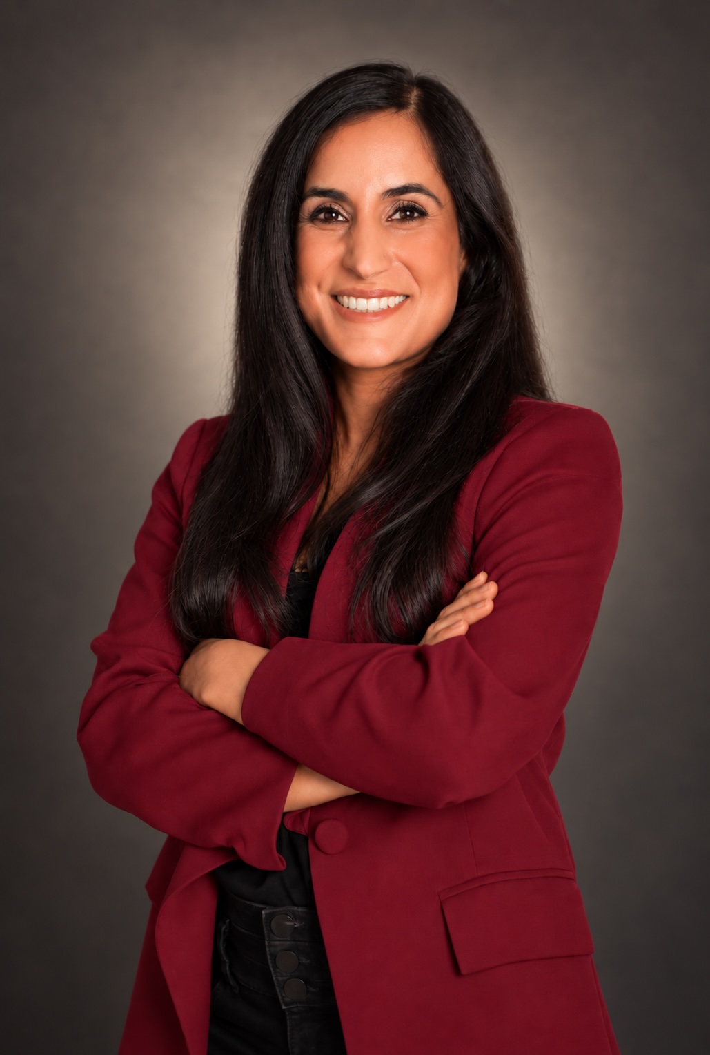 Dr. Remina Panjwani in a red blazer, arms crossed
